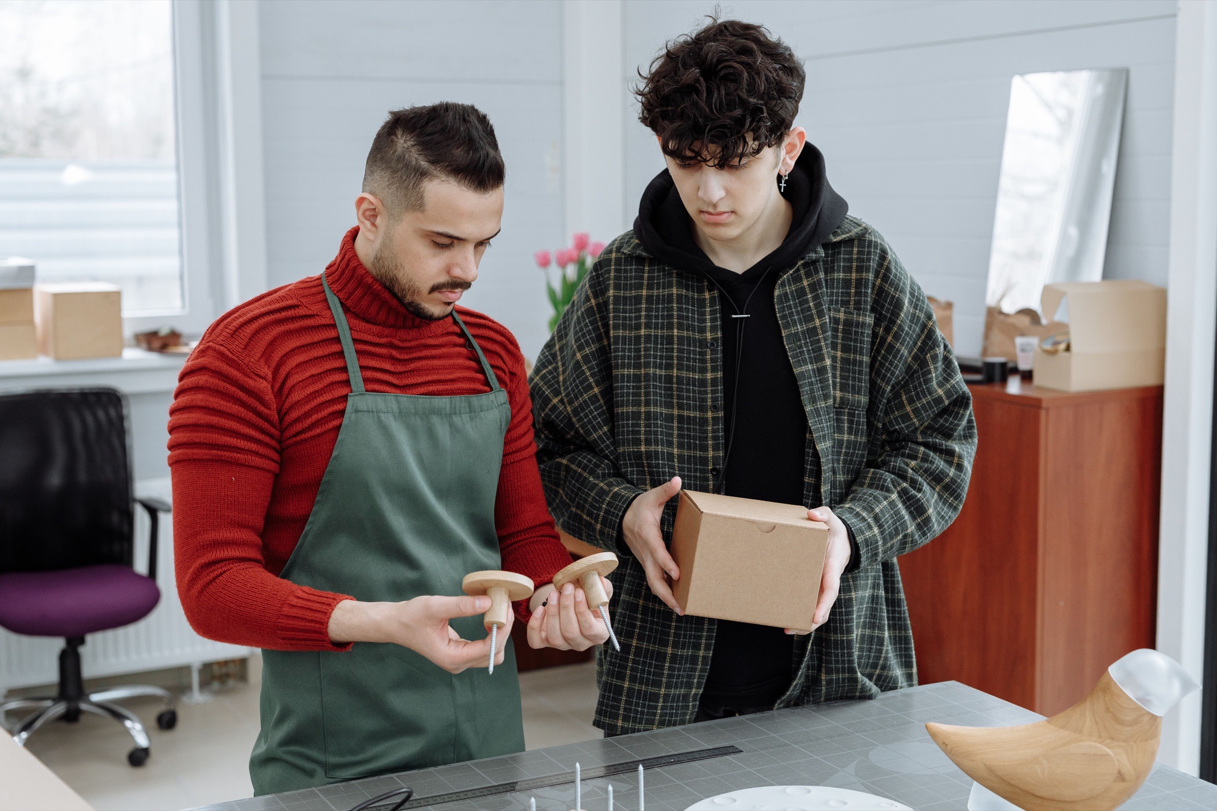 Two people comparing a product sample with its unbranded packaging