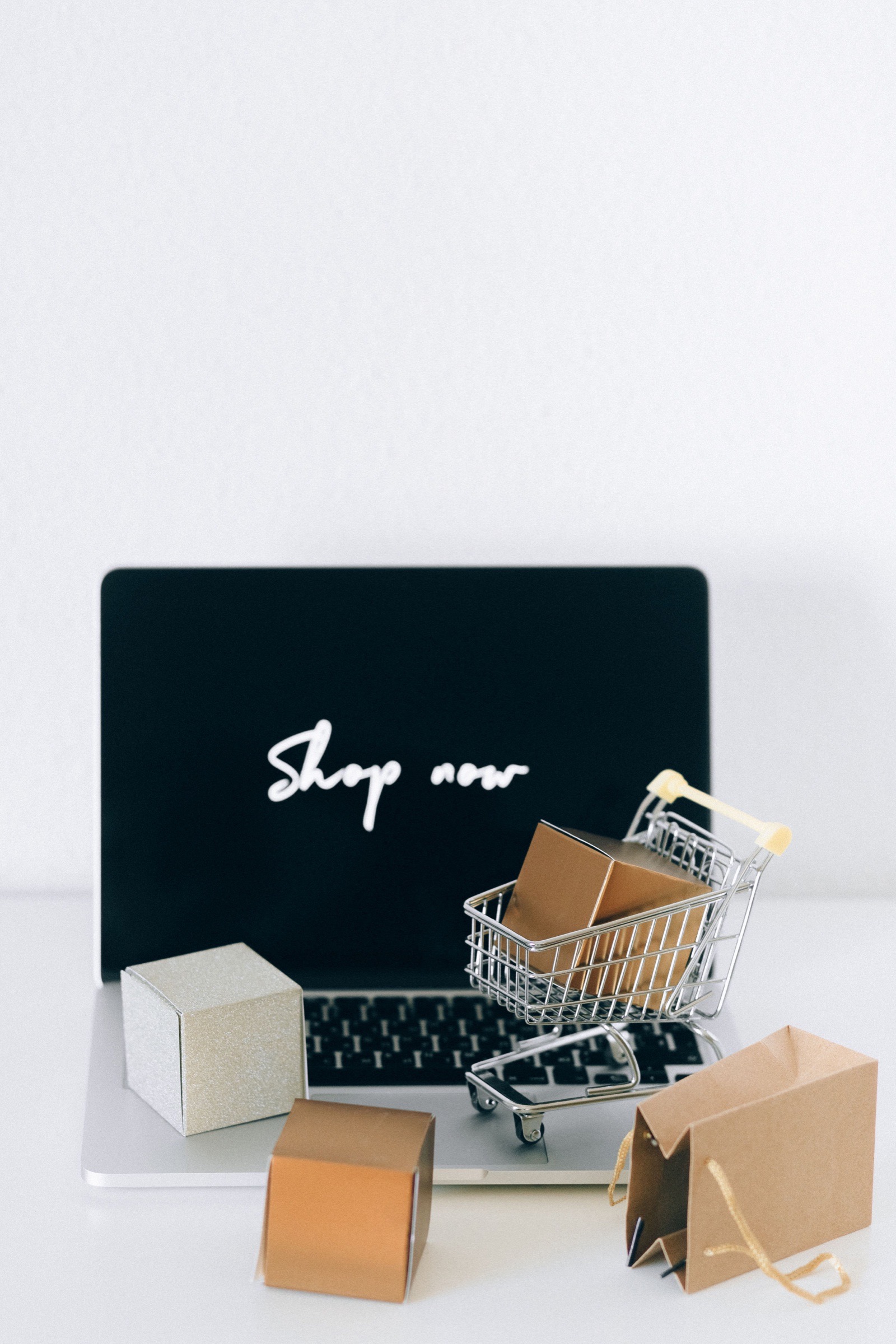 An online retail concept with parcels, a laptop and a shopping basket